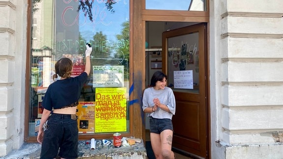 Zwei Frauen stehen vor den Schmierereien am Mitmach-Café in Wurzen.