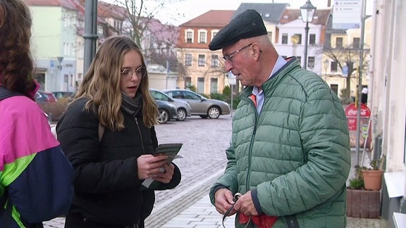 Eine Schülerin redet auf der Straße mit einem älteren Mann