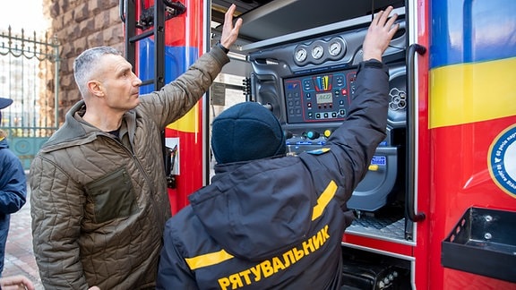 Vitali Klitschko, Bürgermeister von Kiew, unterhält sich bei der Übergabe von Feuerwehrautos aus Leipzig mit ukrainischen Feuerwehrleuten. Seit dem russischen Einmarsch hat die Dreimillionenstadt bereits 65 teils gebrauchte Feuerwehrwagen, 50 moderne Krankenwagen und 52 Busse aus dem Ausland erhalten.