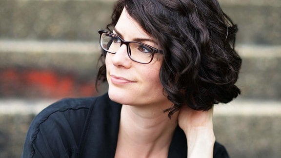 Isabelle Lehn, eine Frau mit dunklen Locken und dunkler Brille