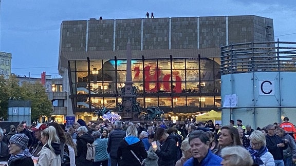 Auf dem Augustusplatz stehen viuele Menschen und warten, dass das Lichtfest 2024 beginnt.