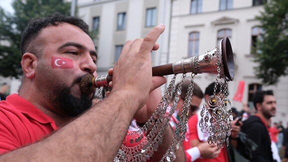 Ein Fan der türkischen Nationalmannschaft macht Musik.