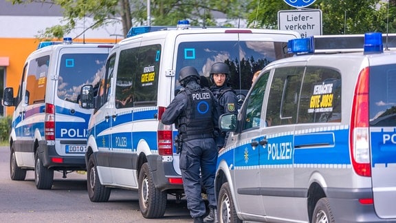 Polizeiwagen und Polizisten an einer Schule in Leipzig.
