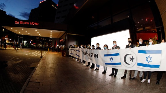 Mitarbeiter des Hotel Westin, die mit einem Banner ein Zeichen gegen Antisemetismus setzen wollen