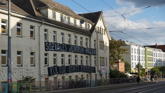 "Soziales Zentrum Helium Kultur statt Kommerz" steht auf einem Transparent an einem Haus in Leipzig.