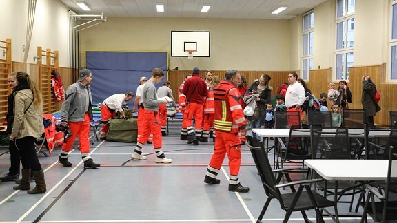 Rettungskräfte in einer zur Notunterkunft umfunktionierten Leipziger Turnhalle