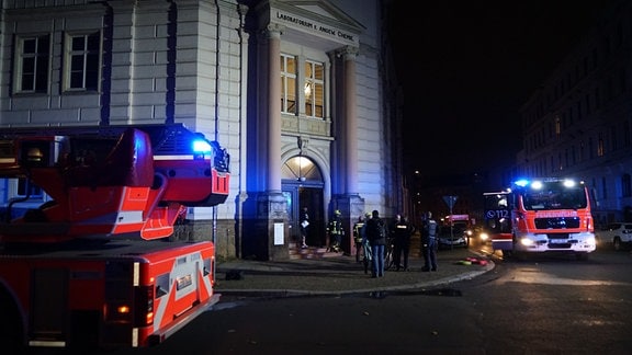 Einsatzkräfte stehen vor dem Fakultätsgebäude.