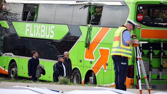 Politiker vor dem verunglückten, grünen Flixbus