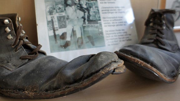 Die abgetragenen Schuhe eines Clowns stehen in einem Regal des Clown-Museums in Leipzig.