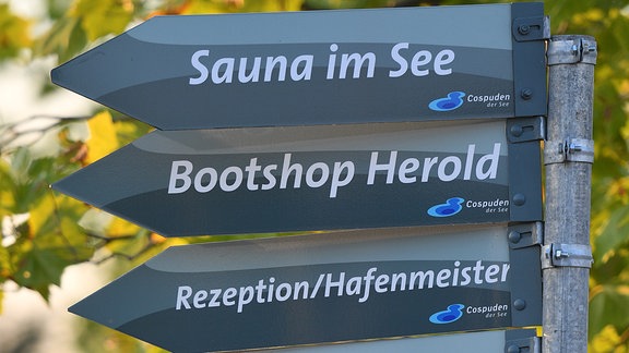 Ein Wegweiser zeigt die Richtung zu Restaurants und Bootsvermietungen am Cospudener See in Markkleeberg (Sachsen)