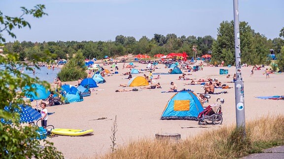 Badegäste tummeln sich bei warmem Wetter am Nordstrand des Cospudener Sees bei Leipzig.