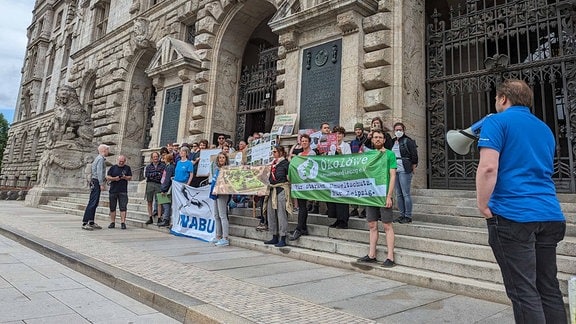 Mehrere Menschen mit Transparenten vor dem Neuen Rathaus Leipzig