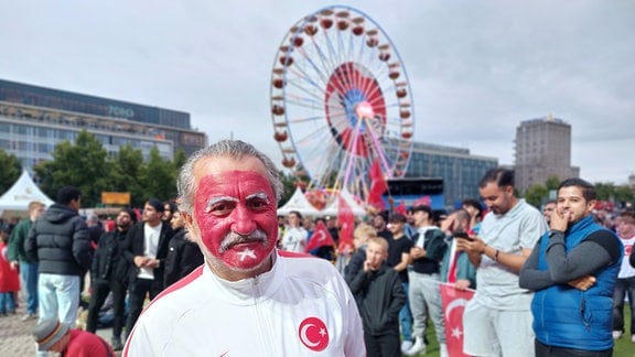 Ein Mann mit einer geschminkten türkischen Flagge im Gesicht.