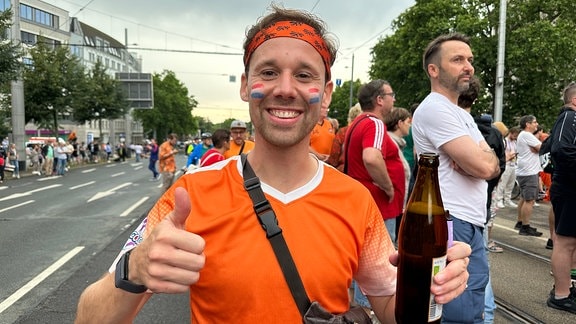 Ein niederländischer Fußballfan lächelt in die Kamera. 