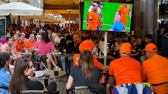 Viele Fußballfans in einem Biergarten. 