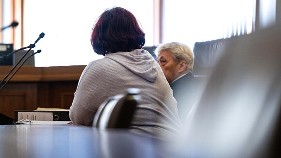Ein Mann und eine Frau im Verhandlungssaal des Landgerichts Leipzig
