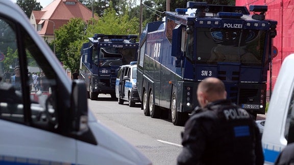 Wasserwerfer der Polizei stehen an einer Straße unweit vom Bruno-Plache-Stadion in Leipzig