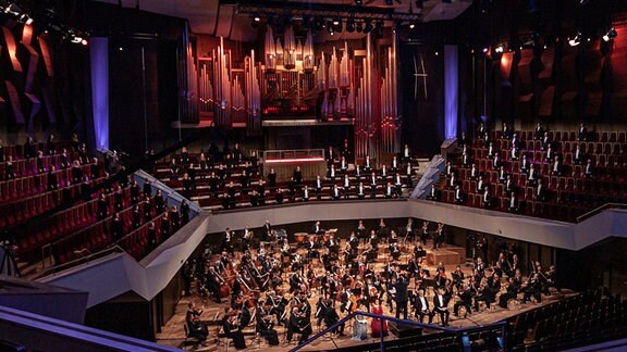 Orchestermusiker sitzen in der Konzerthalle des Gewandhauses auf der Bühne.