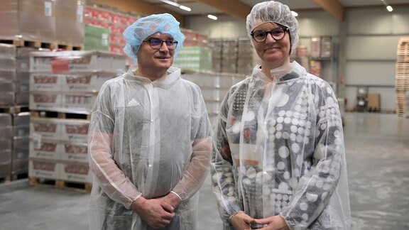 Ein Mann und eine Frau stehen in einer Fabrik.