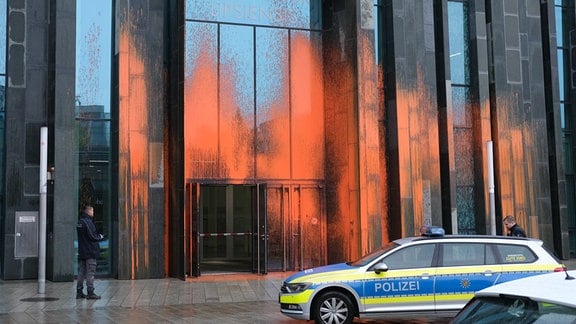Orange-Farbe haftet an der Fassade eines Gebäudes der Universität Leipzig