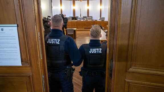 Justizmitarbeiter stehen in der Tür zum Verhandlungssaal im Landgericht Leipzig.