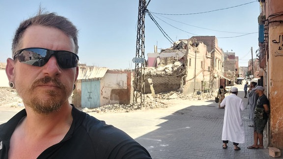 Porträt eines Radfahrers vor Erdbebentrümmern in Marrakesch