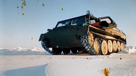 Ein Panzer fährt über verschneiten Untergrund.