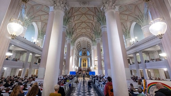 Teilnehmer des Friedensgebets sitzen in die Nikolaikirche in Leipzig.