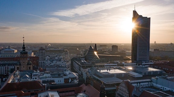 Die Sonne geht hinter dem City-Hochhaus auf. 