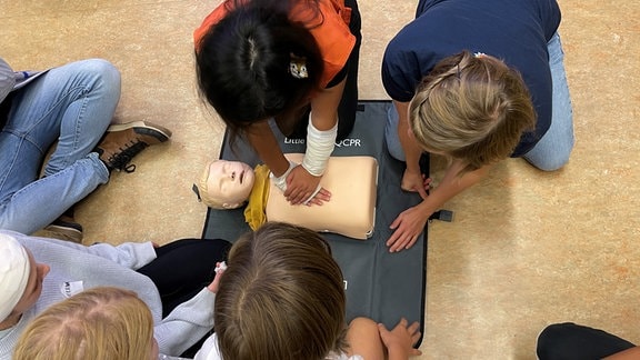 Schülerinnen und Schüler üben in einem Erste-Hilfe-Kurs. 