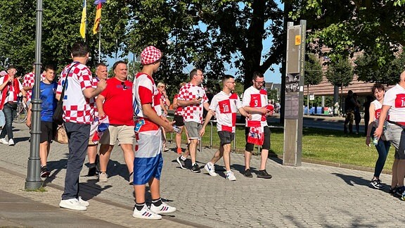 Fußballfans in den Trikots der kroatischen Nationalmannschaft laufen durch die Innenstadt von Leipzig.