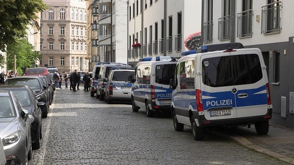 Großes Polizeiaufgebot in einer Straße mit Wohngebäuden