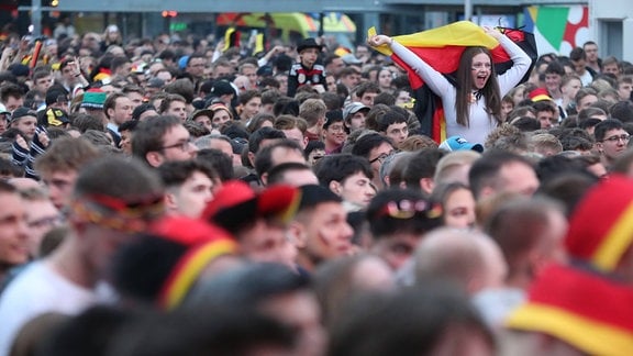 Eine bunte Menschenmasse: Deutschland-Fans feiern mit Deuitschlandfahnen und anderen schwarz-rot-goldenen Fanartikeln beim Public Viewing auf dem Leipziger Augustusplatz das Eröffnungsspiel der Fußball-EM.