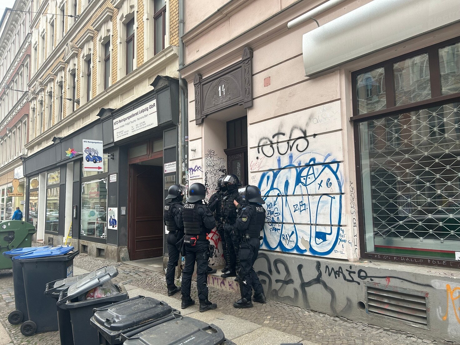 Polizisten stehen vor einem Gebäude in Leipzig.