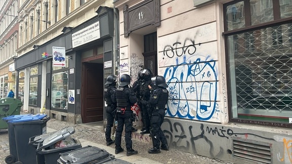Polizisten stehen vor einem Gebäude in Leipzig.