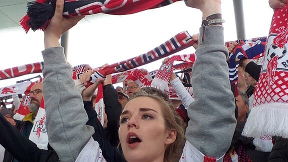 Ein Mädchen hält im Stadion einen RBL-Fanschal hoch.