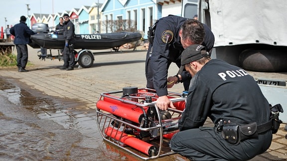 Thüringer Polizisten bereiten am Dienstag (10.04.2012) einen Tauchroboter für seinen Einsatz im Cospudener See in Markkleeberg (Leipzig) vor. Rettungskräfte haben am gleichen Tag ihre Suche nach dem vermissten Taucher in dem See fortgesetzt.