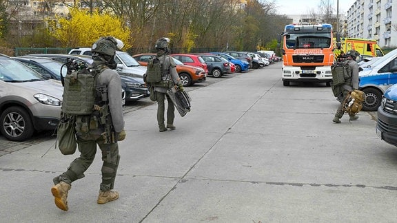 SEK-Einsatzkräfte auf der Straße im Hintergrund eine Feuerwehr