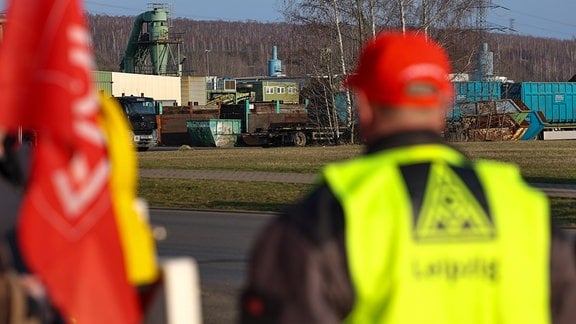 Ein Streikposten steht vor dem Besuch von Sachsens Ministerpräsident Kretschmer vor dem Recycling-Betrieb SRW. 