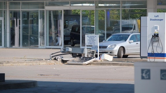 An einer Tankstelle sind bei einem Unfall Autos und Geräte beschädigt worden.