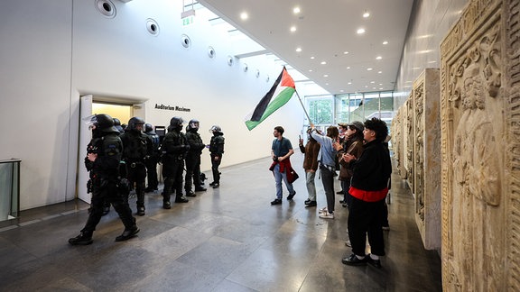 Polizisten stehen vor dem besetzten Audimax der Universität Leipzig.