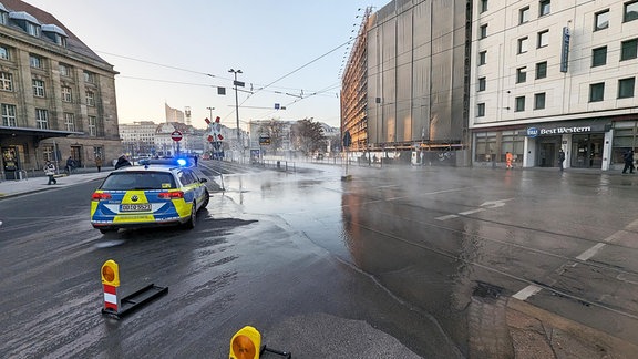 Polizei sperrt wegen eines Wasserrohrbruch eine Straße ab.