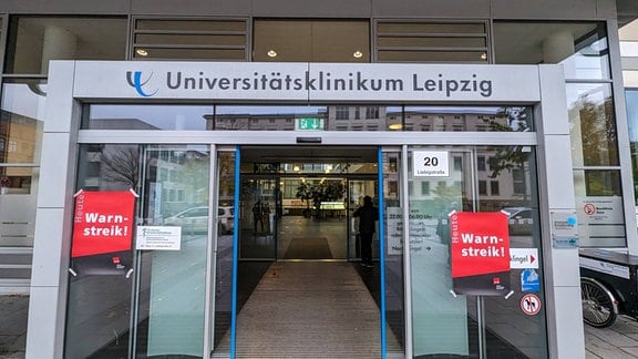 Eingang des Uniklinikums Leipzig mit Flyern: Warnstreik!