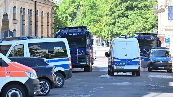 Wasserwerfer der Polizei stehen an der Polizeidirektion in Leipzig. 