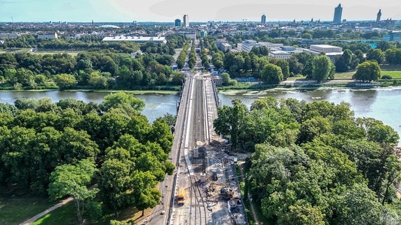 Bauarbeiter und Gleisbauer arbeiten an der Gleistrasse vor der Zeppelinbrücke in der Jahnallee. 