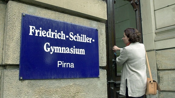 Eine Lehrerin schließt das Portal des Friedrich-Schiller-Gymnasiums im sächsischen Pirna zum Beginn der Sommerferien ab
