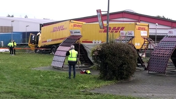 Verunglückter LKW auf einer Wiese vor einem Gebäude