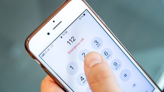 Ein Mann wählt die europaeische Notrufnummer 112 auf einem Smartphone.