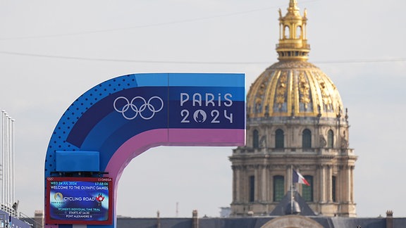 Vor den Olympischen Sommerspielen, Olympia Paris 2024, eine Anzeigetafel und die Olympischen Ringe sind vor der Kuppel des Invalidendoms zu sehen.