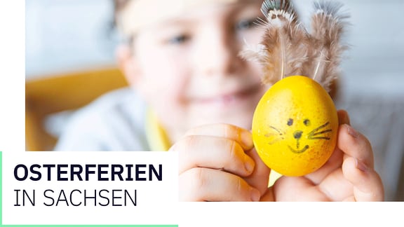 Ein Junge mit einem Osterei darauf di Schrift osterferien in Sachsen